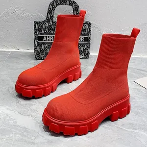 Detailed view of bright red flyknit chunky platform sock boots on a marble floor