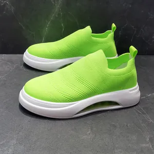 Vista laterale di sneaker a calzino in maglia verde neon traspirante con suole bianche