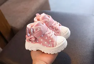 Detailed view of pink sparkly girls' winter snow boots with bunny ear bow.