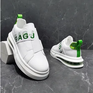 Side view of white men's fashion sneakers featuring green elastic bands and air cushion
