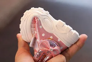 Close-up showing the soft and highly flexible white lug sole of pink glittery toddler shoes