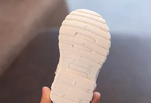 Close-up detail view of the thick anti-slip white rubber sole on children's winter snow boots