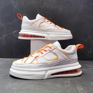 Vista lateral profesional de zapatillas blancas para hombre con cámara de aire y detalles naranjas