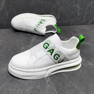 Detail view of white casual men's slip-on sneakers with green accents and elastic bands