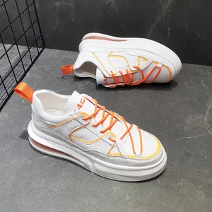 Vista detallada de zapatillas blancas para hombre con toques naranjas y cámara de aire