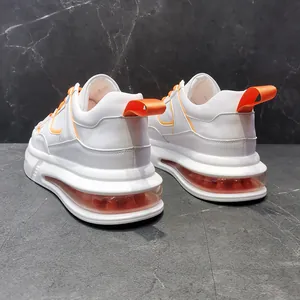 Vista detallada de zapatillas de plataforma blancas con suela de cámara de aire naranja.