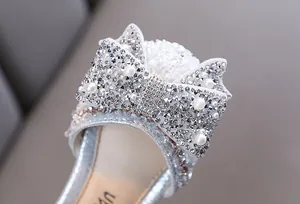 Close-up detail of girls' silver princess shoe featuring a bow with rhinestones and pearls
