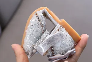 Detailed view showing the flexibility of a silver girl's rhinestone princess shoe