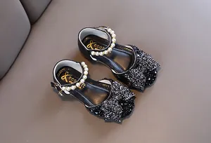 Vue détaillée de chaussures de princesse à paillettes noires avec bride en perles