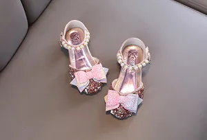 Vue détaillée de chaussures de princesse roses à paillettes avec perles et nœuds papillon
