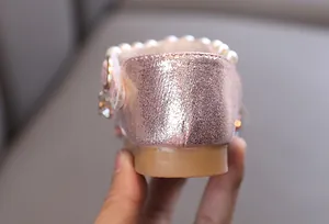 Détail rapproché du talon de la chaussure de princesse rose pailletée avec perles