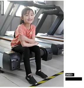 Close-up of lightweight black water shoes worn by a child on a gym treadmill