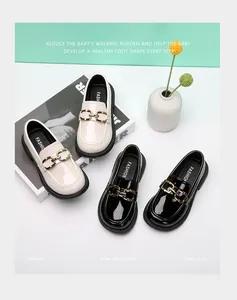 Mocassins en cuir verni pour enfants en noir et blanc avec boucles dorées élégantes
