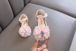 Close-up of pink glitter girl's princess shoes with pearls and lace bow