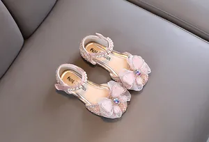 Detailed view of pink glittery girls princess shoes with bow and pearl strap