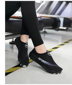 Breathable black aqua shoes for fitness and water sports on model in gym setting
