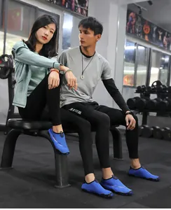Asian couple wearing blue breathable non-slip aqua shoes in a modern fitness gym setting