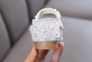 Detail view of sparkly crystals and pearls on girls' princess flat shoe heel