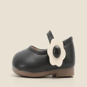 Close-up of black baby Mary Jane shoe with cute white flower detail