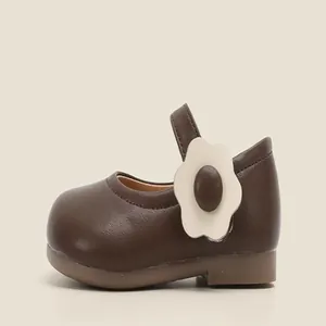 Close-up of brown baby Mary Jane shoe with a cute white flower detail and soft sole