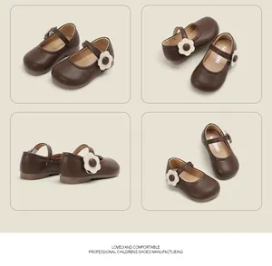 Detail view of brown leather Mary Jane baby shoes featuring a stylish white flower decoration