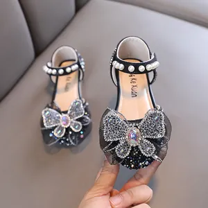 Elegant girl's black princess shoes with sparkling rhinestone bow and pearl strap