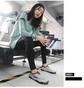 Close-up of gray breathable aqua shoes worn by a model in a fitness gym setting.