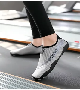 Macro view of breathable grey striped yoga fitness shoes worn on a gym treadmill
