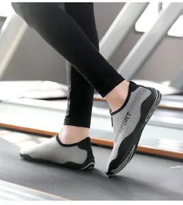 Action detail of gray striped breathable yoga fitness shoes on a treadmill gym setting