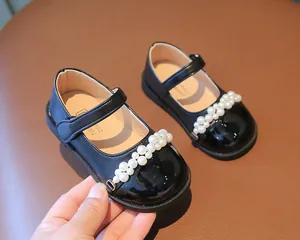 Detailansicht von schwarzen Mary-Jane-Schuhen für Mädchen mit Perlenverzierung auf der Kappe