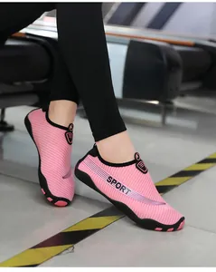 Side view of pink breathable quick-dry aqua shoes worn on feet for beach and yoga