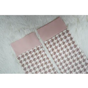 Primer plano de tela con motivo de pata de gallo y cintura rosa en pantalones
