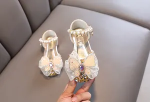 Detalle de zapato de princesa para niña con correa de perlas y mariposa de malla fina