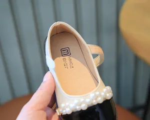 Detailansicht von Mädchen-Mary-Jane-Schuhen mit Perlendekor und schwarzem Lackleder