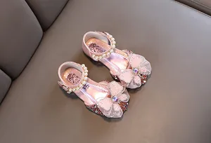 Elegantes zapatos de princesa rosa con purpurina, correa de perlas y gran lazo de encaje