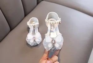 Primer plano de zapatos de princesa para niña con un gran lazo de encaje blanco