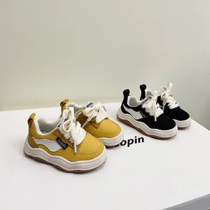 Gedetailleerd overzicht van gele en zwarte peutersneakers met zachte zolen en veters.
