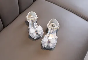 Vista detallada de zapatos de princesa para niña en plata brillante con lazo de encaje
