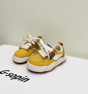 Detailweergave van gele canvas peutersneakers met zachte zolen en witte veters