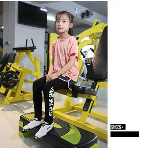 Detail view of breathable non-slip fitness shoes on a child model in a gym