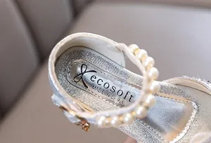 Vista macro detallada de elegantes zapatos de princesa plateados con perlas finas