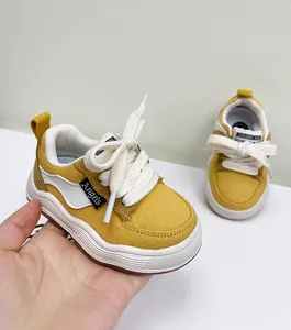 Detailopname van gele canvas peuterschoenen met zachte zool en witte veters details