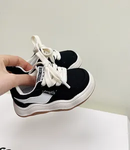 Gedetailleerde weergave van zwart-witte peutersneakers voor jongens met zachte rubberen zolen