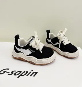 Detailweergave van zwart-witte peutersneakers met zachte dikke zolen op een displaydoos