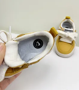 Gedetailleerde close-up van mosterdgele peuterschoenen met zachte binnenzool.