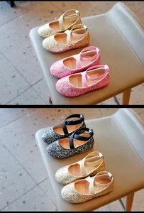 Close-up detail of girl's glittery princess shoes featuring elegant elastic cross straps