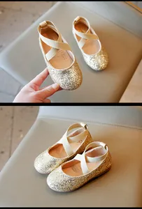 Detailed view of girls' gold glitter ballet flats with elastic cross straps