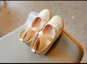 Gold glitter Mary Jane flats for girls with cross elastic straps.