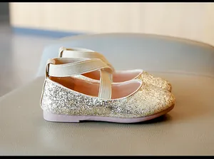 Detailed side view of golden glitter girls princess shoes with elastic criss-cross straps