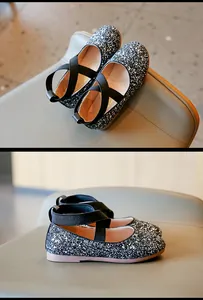 Detailed macro view of sparkling black glitter girl shoes with elastic cross straps
